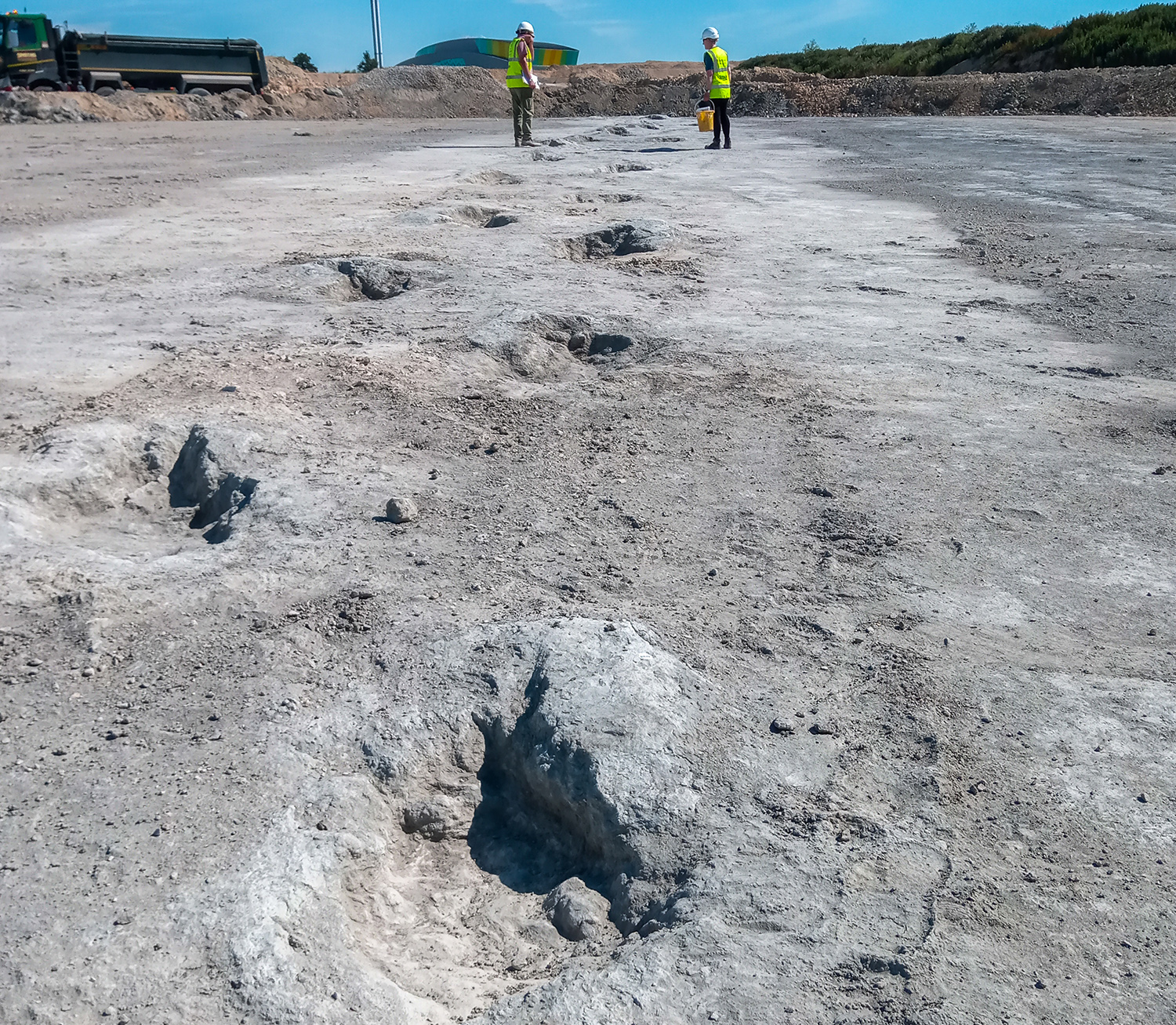 One dinosaur path is seen with two workers in the background.