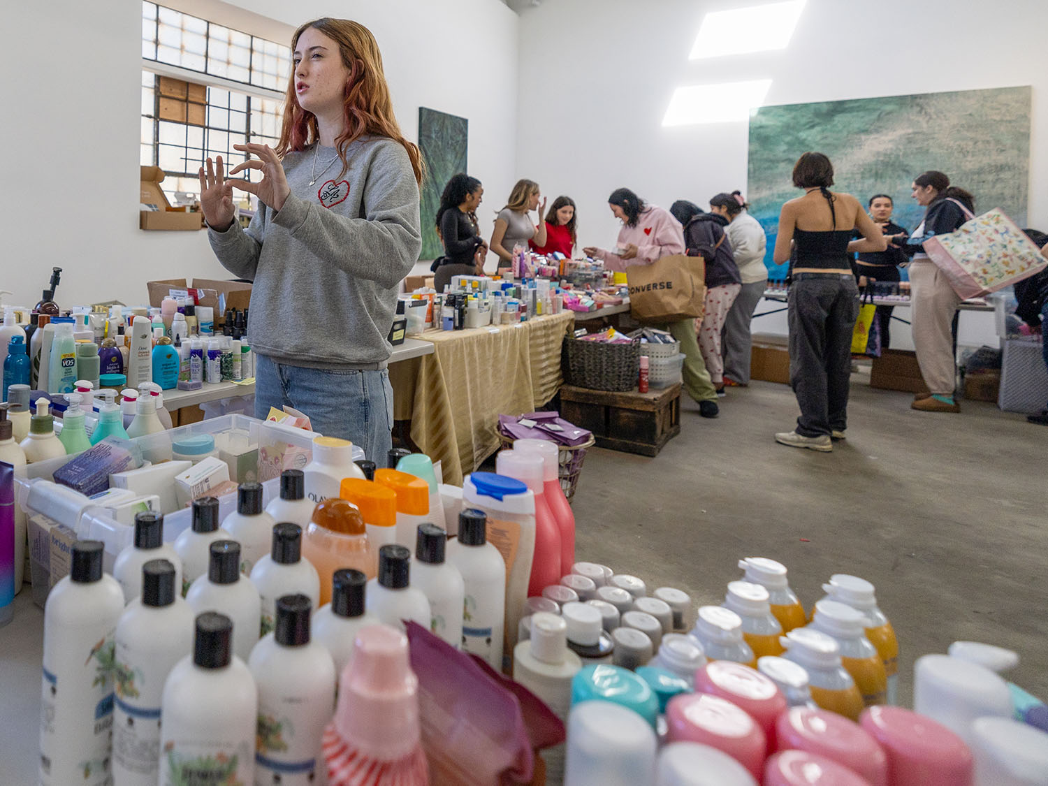 Avery Colvert and other teens in a warehouse where cosmetics have been placed on tables.