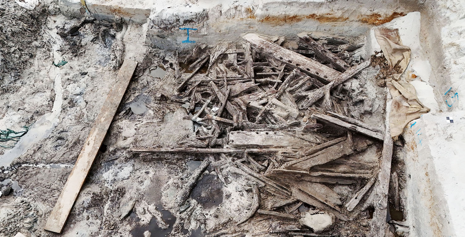 A pile of ancient wood pieces at an excavation site.