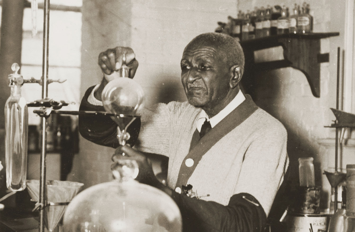 Older George Washington Carver working in a lab.