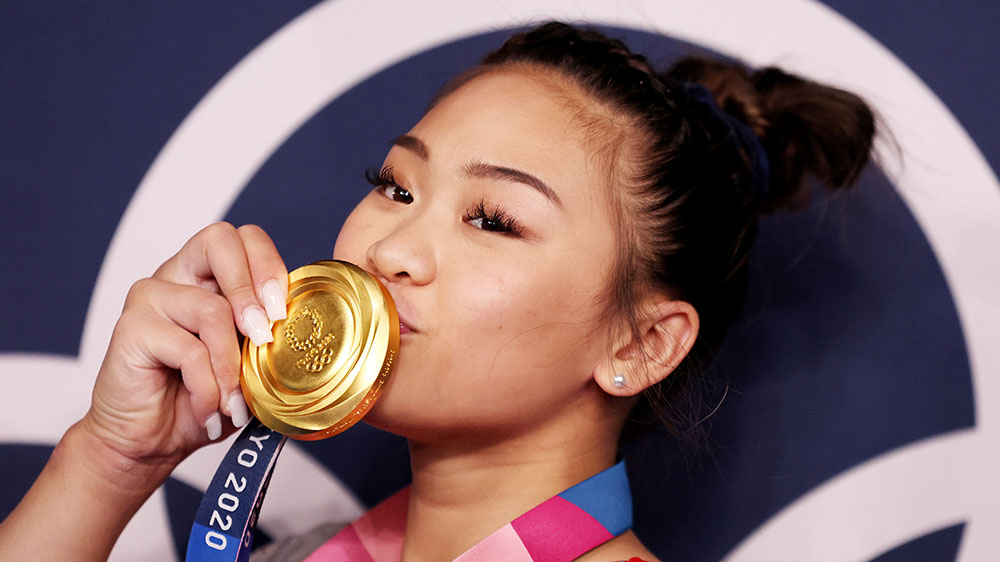 Closeup of Suni Lee kissing her Olympic gold medal