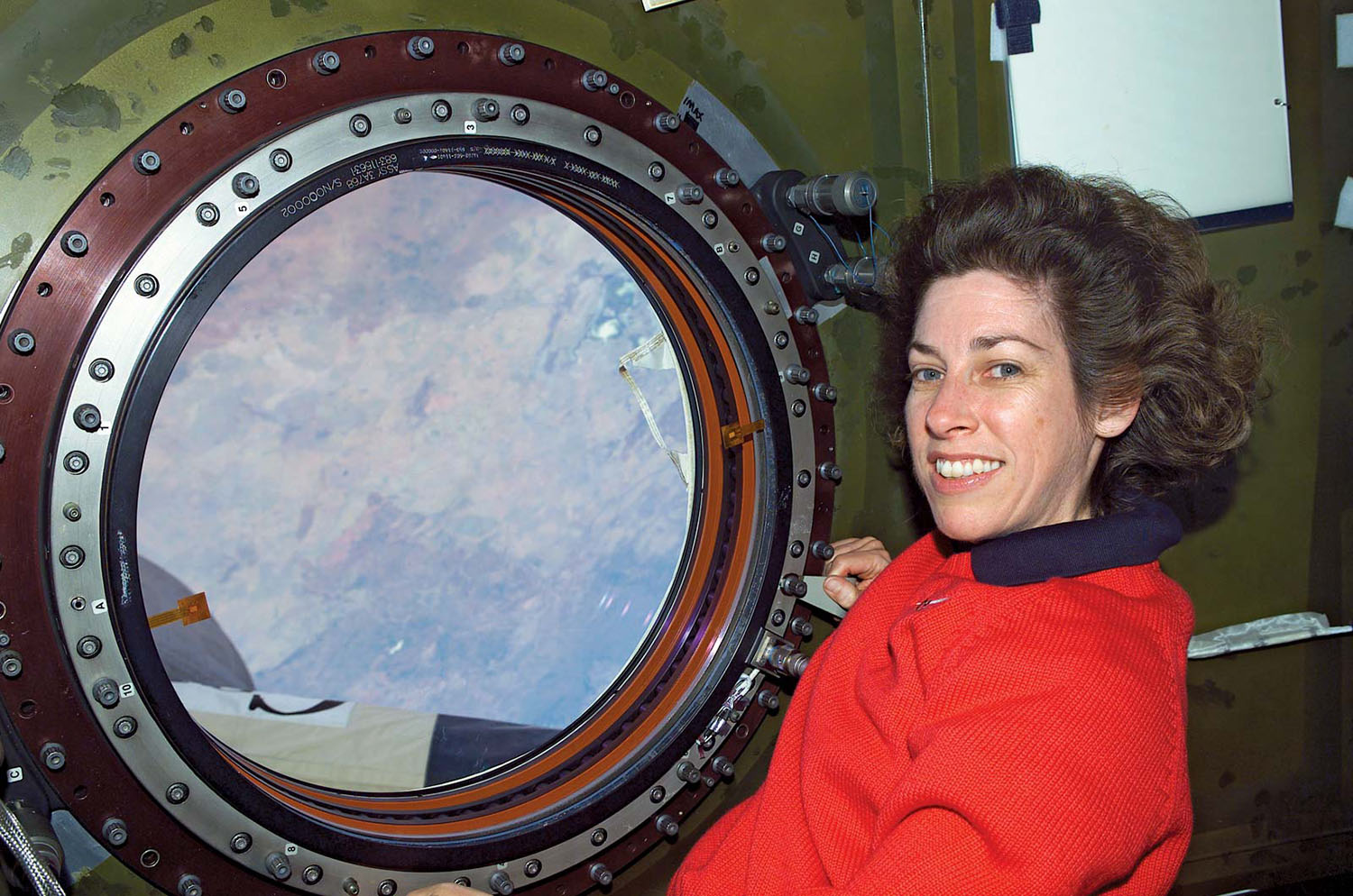 Ellen Ochoa poses for a photo inside a module of the International Space Station.