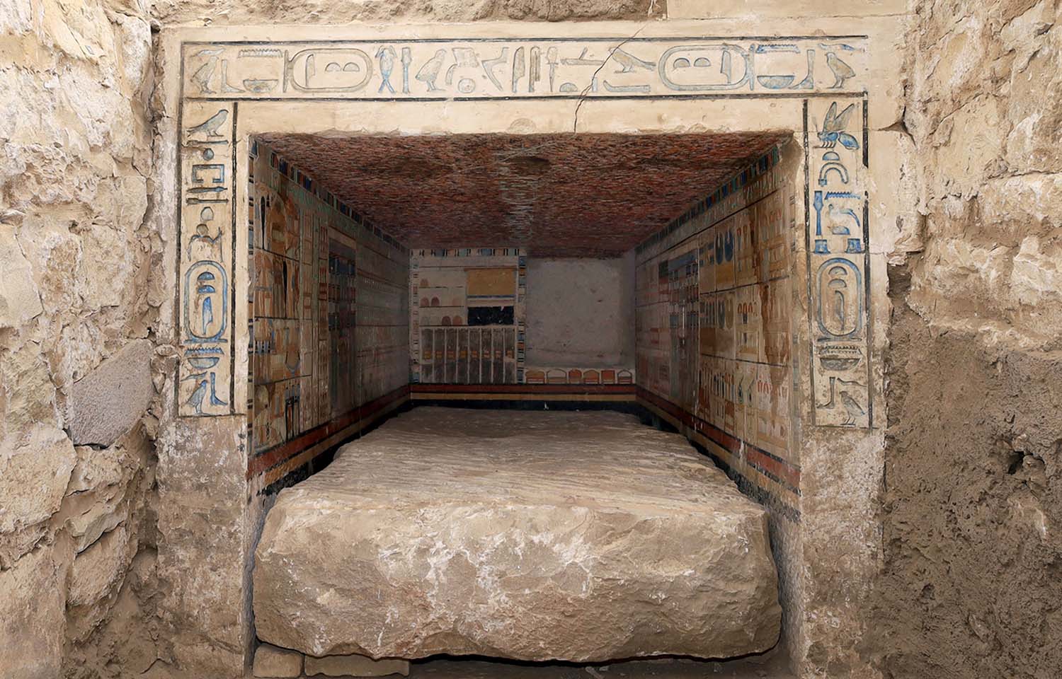 The entrance of a tomb has artwork on the outside and the inside.