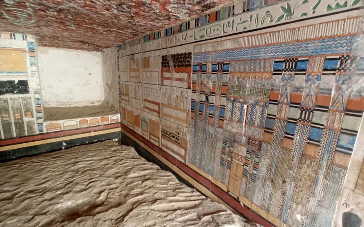 The interior of an ancient tomb contains colorful paintings and elaborate carvings.