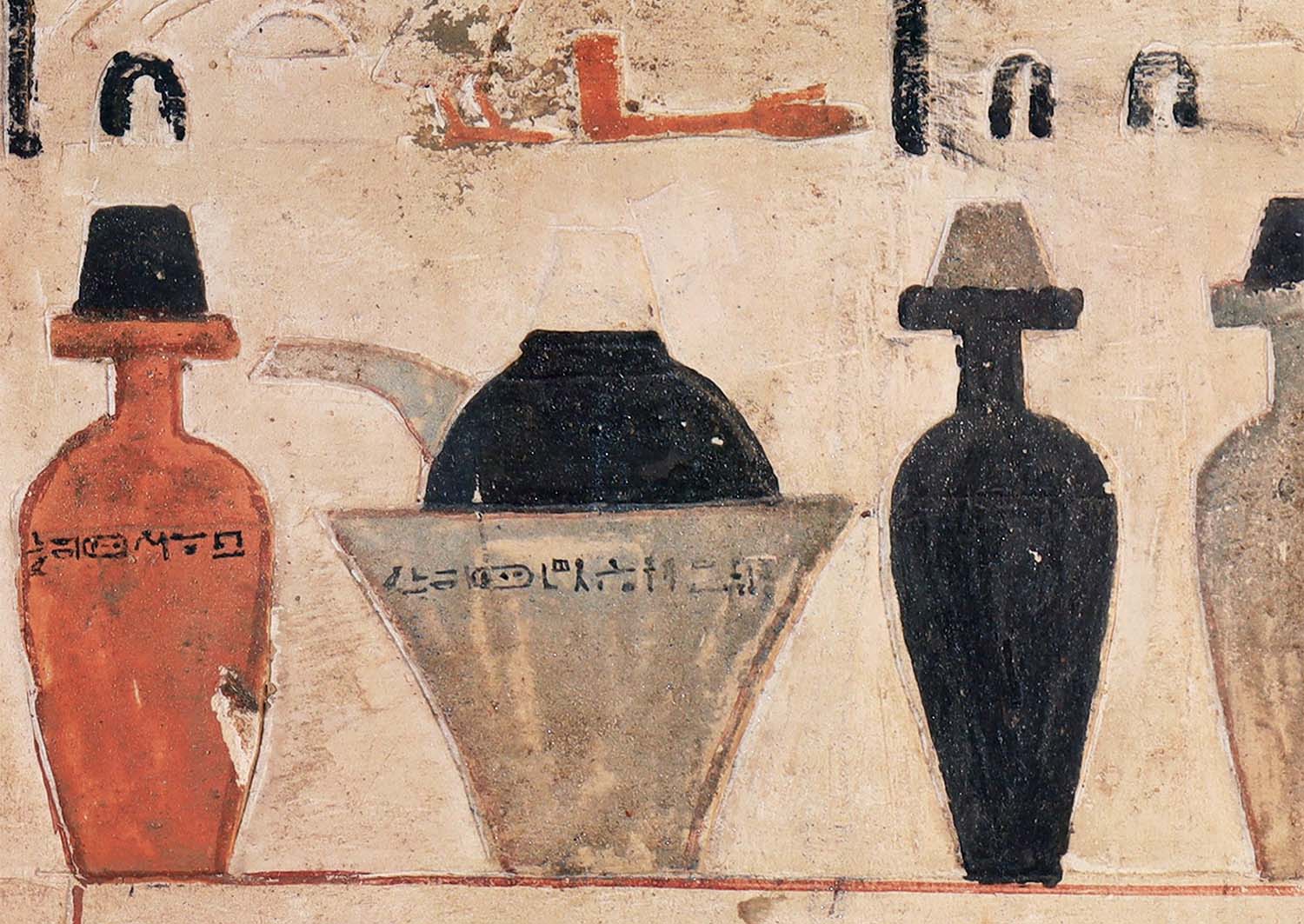 Medicine bottles with hieroglyphics on them are painted on a wall.