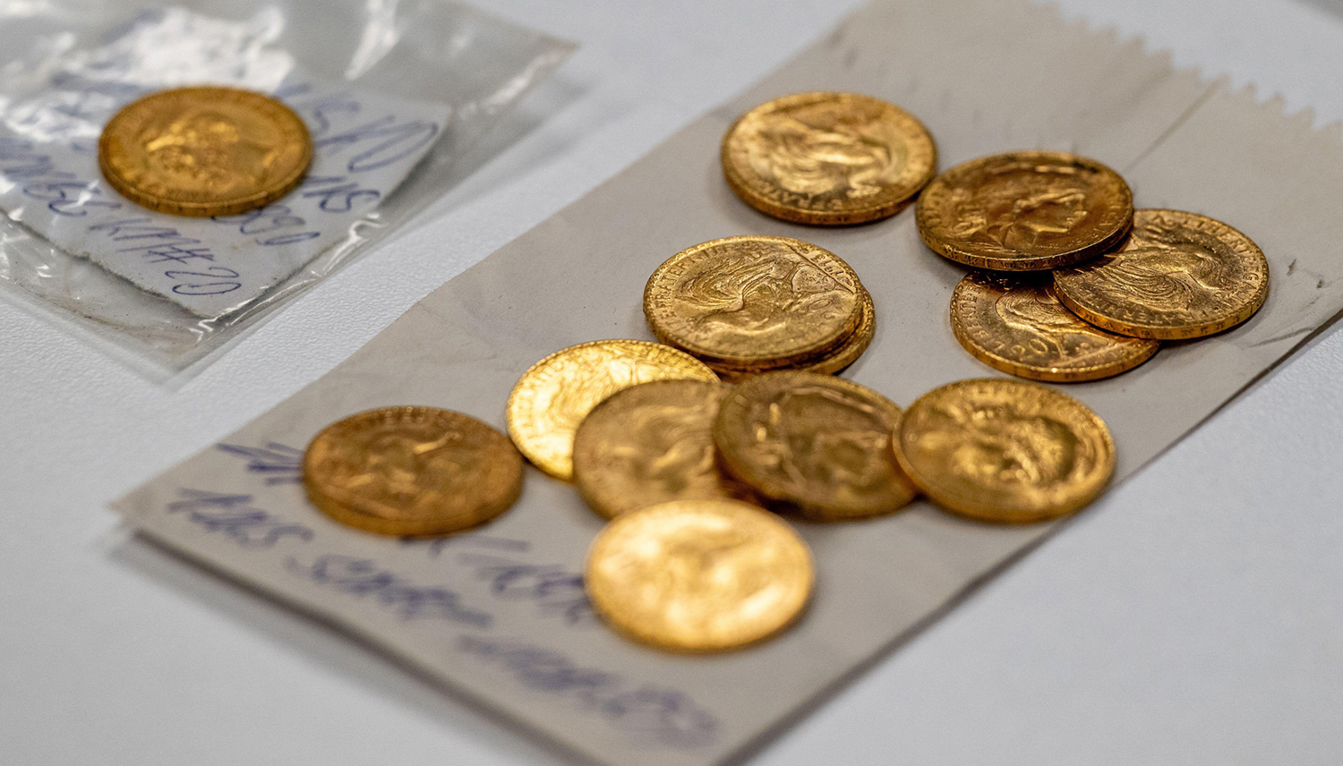 Twelve coins have been placed on a piece of paper with writing on it.