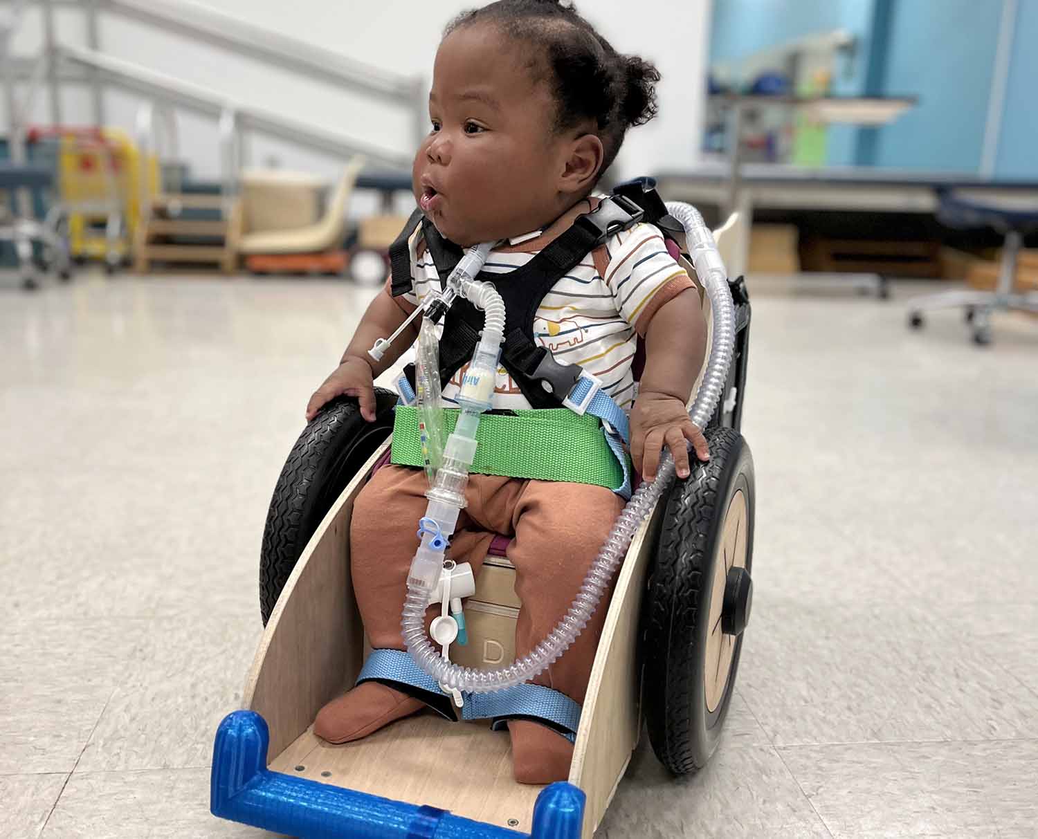 A toddler sits in a 3D printed wheelchair.