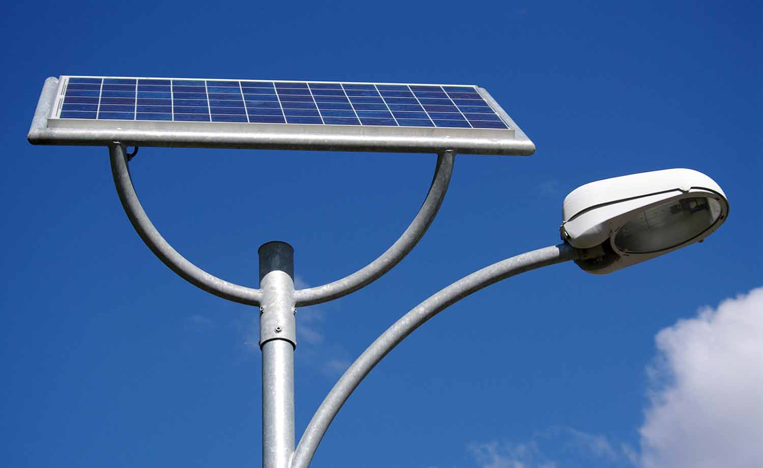 A solar panel is attached to a street light.