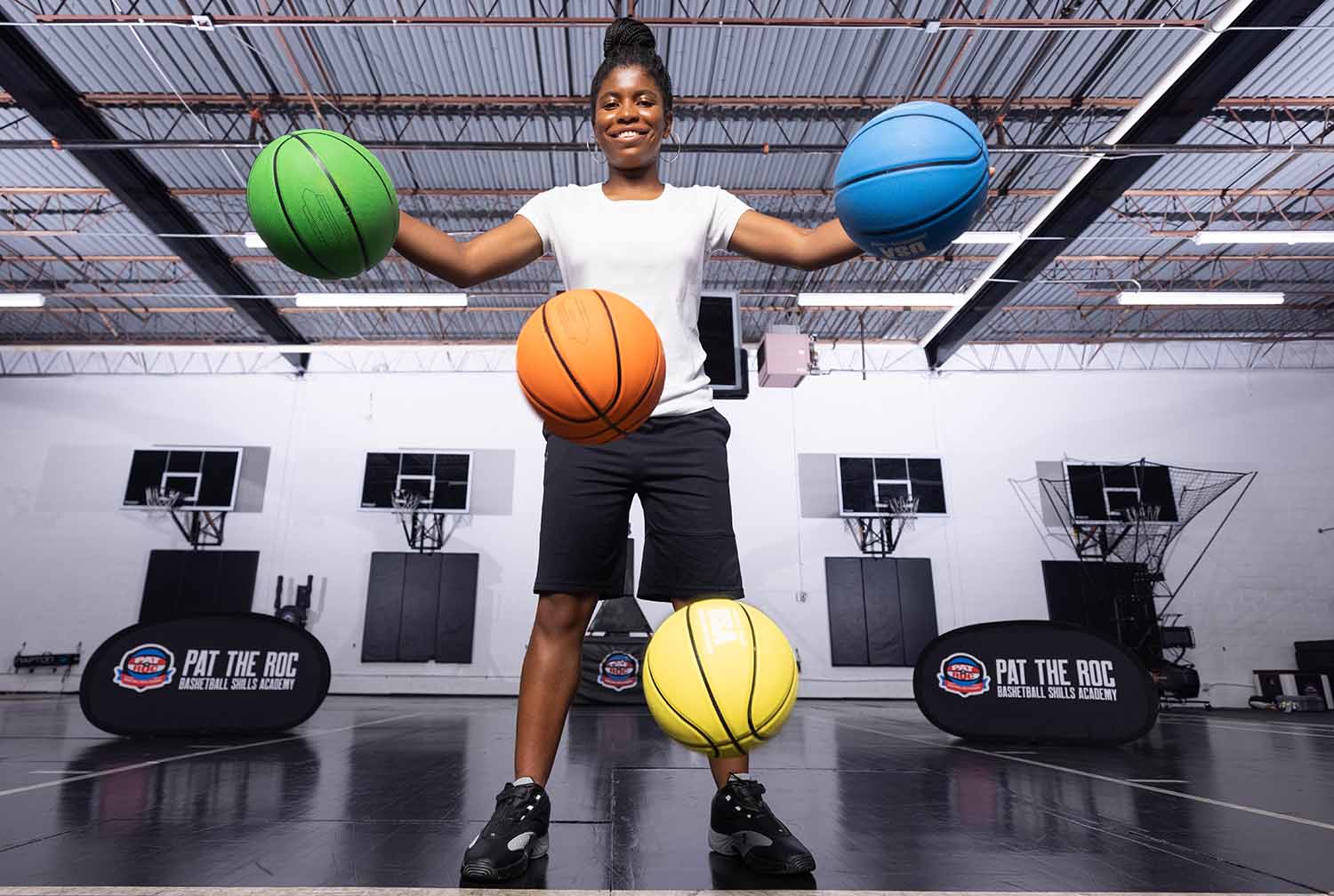 Zaila Avant-Garde smiles as she dribbles four basketballs at once.