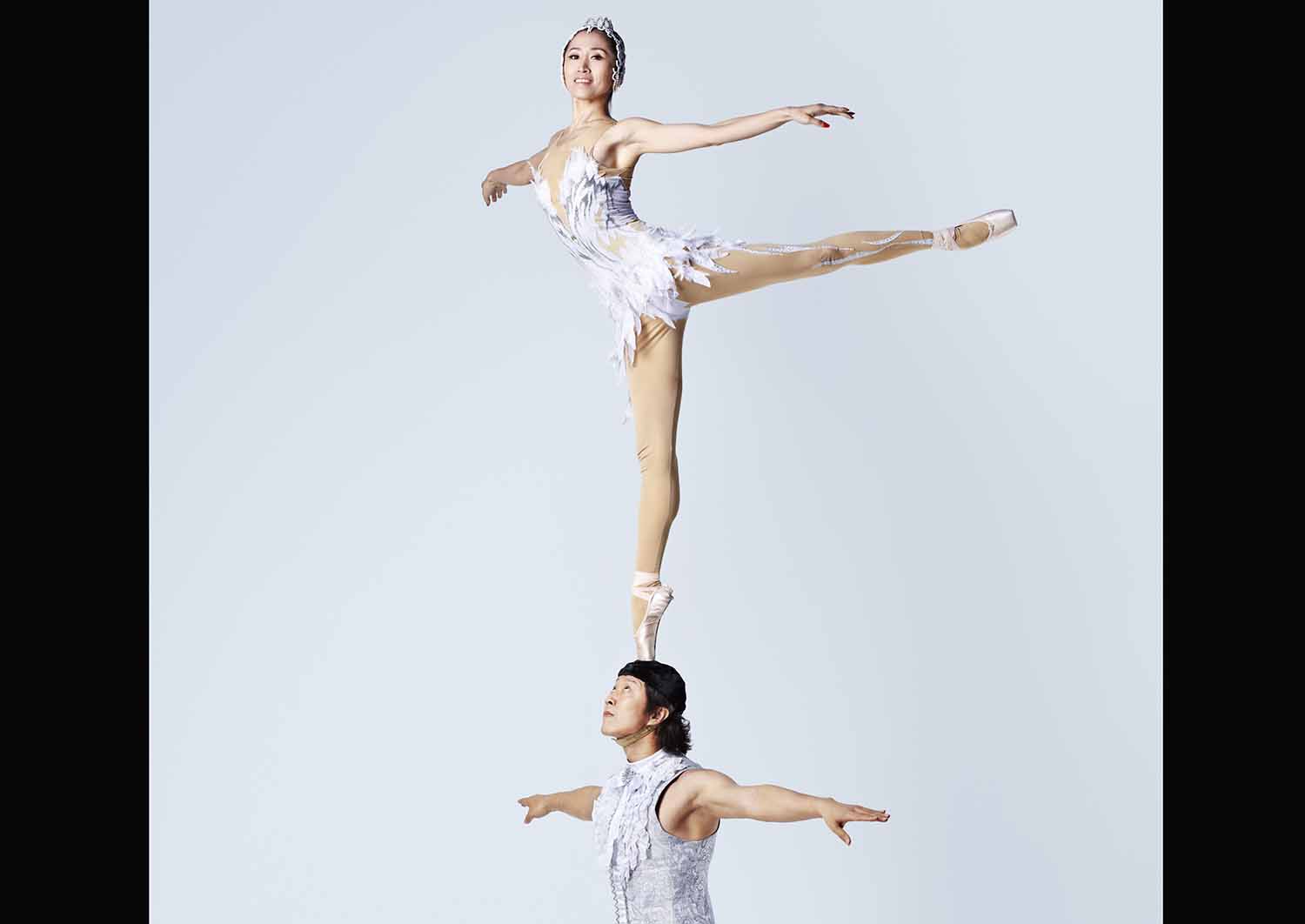 Wu Zhengdan stands on her toe in a pointe shoe on Wei Baohua’s head as she extends the other leg.