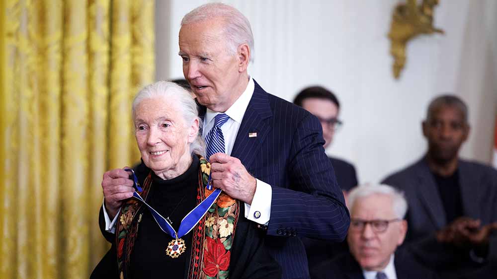 President Joe Biden places the Medal of Freedom around Jane Goodall’s neck.