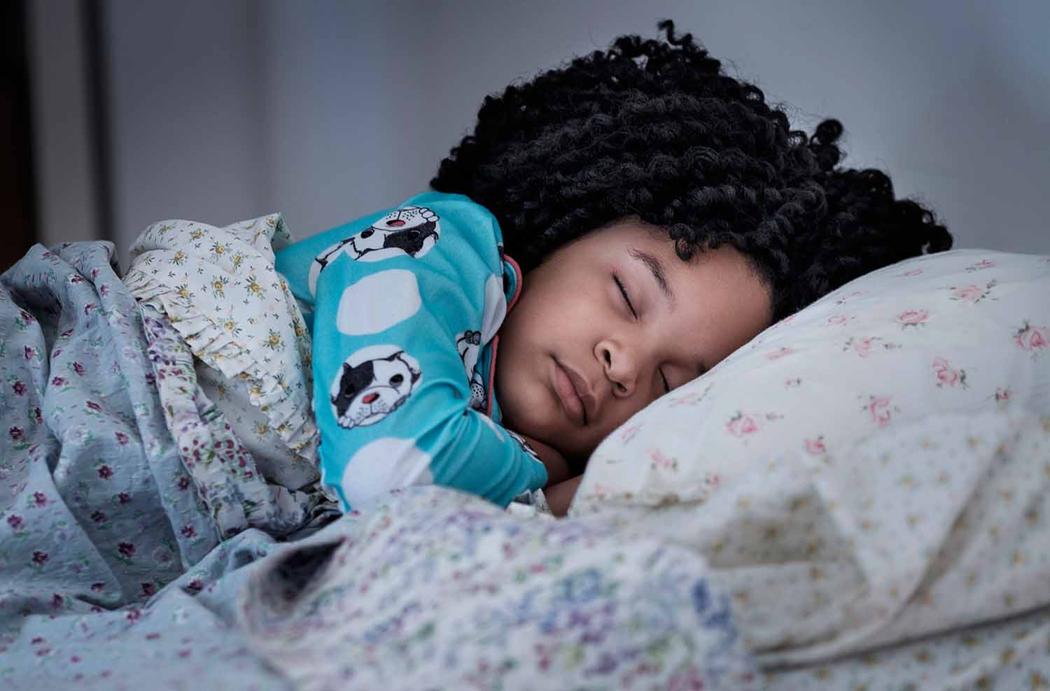 A child sleeps in a bed.