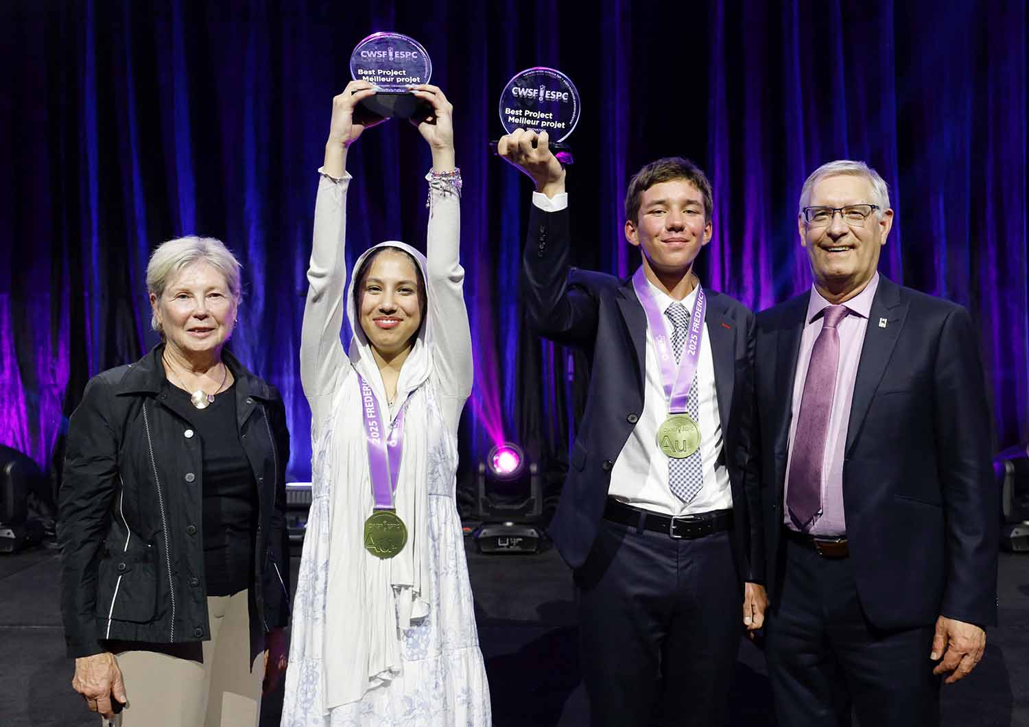 Two teens pose with two adults and hold up awards reading CWSF Best Project.