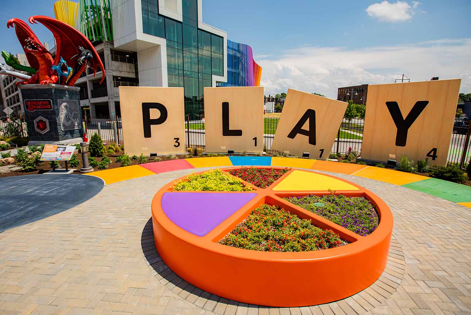 The exterior of the Strong Museum of Play shows a giant Trivial Pursuit gamepiece and giant Scrabble tiles spelling out PLAY in front of the building.