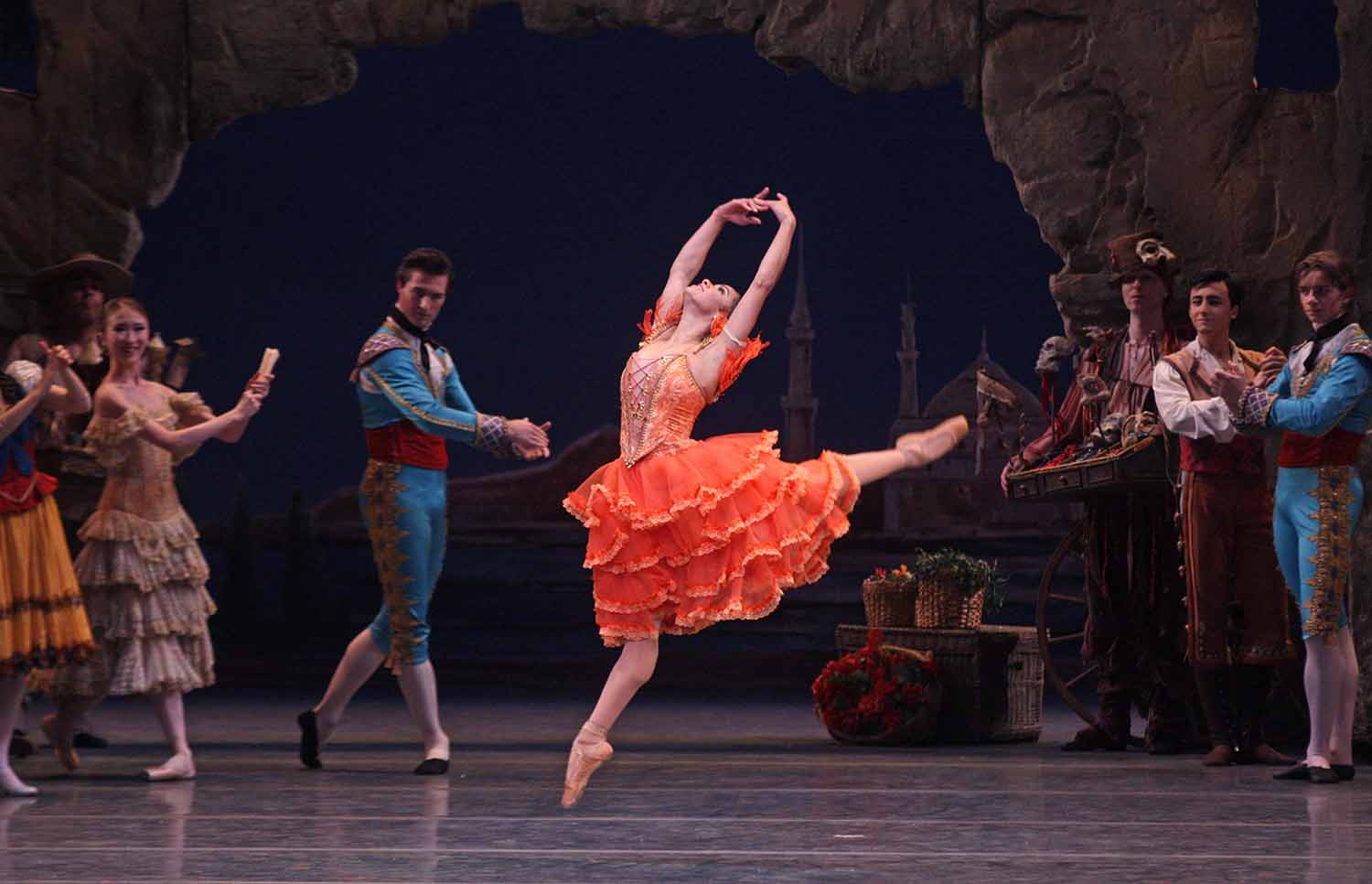 Misty Copeland dances a solo as other dancers pose around her.