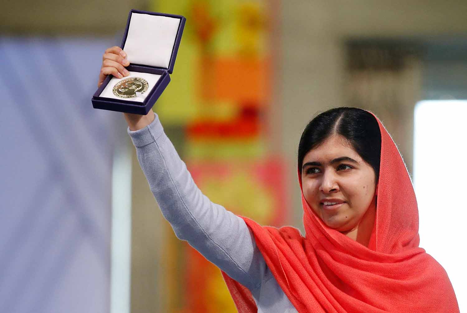 Young Malala Yousafzai holds up the medal she received upon winning the Nobel Prize.