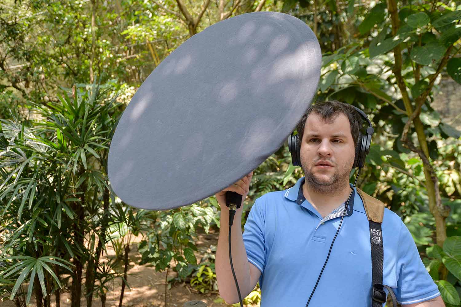 Juan Pablo Culasso wears headphones and carries equipment in an outdoor setting.