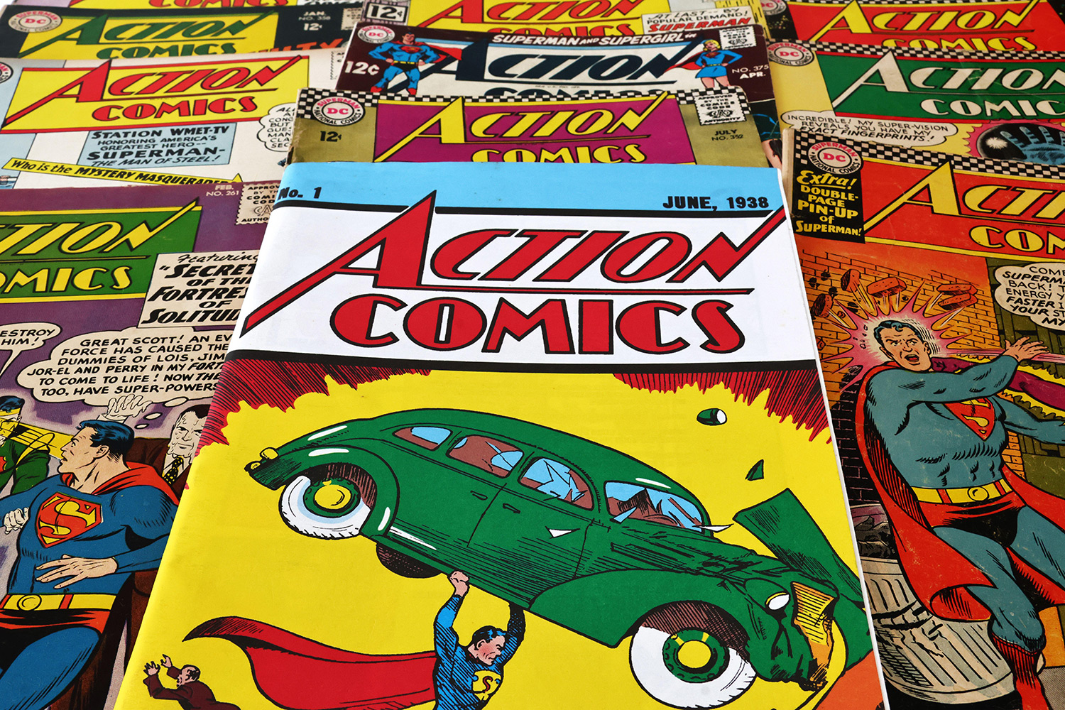 Several Action Comics comic books with Superman on the cover are laid out on a surface.