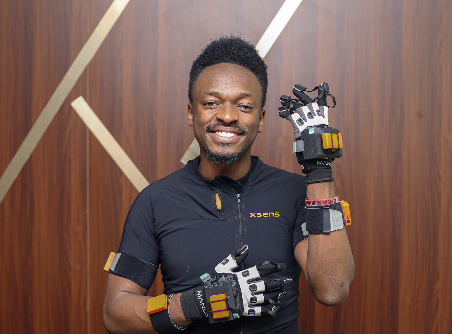 Elly Savatia smiles while wearing wired gloves.