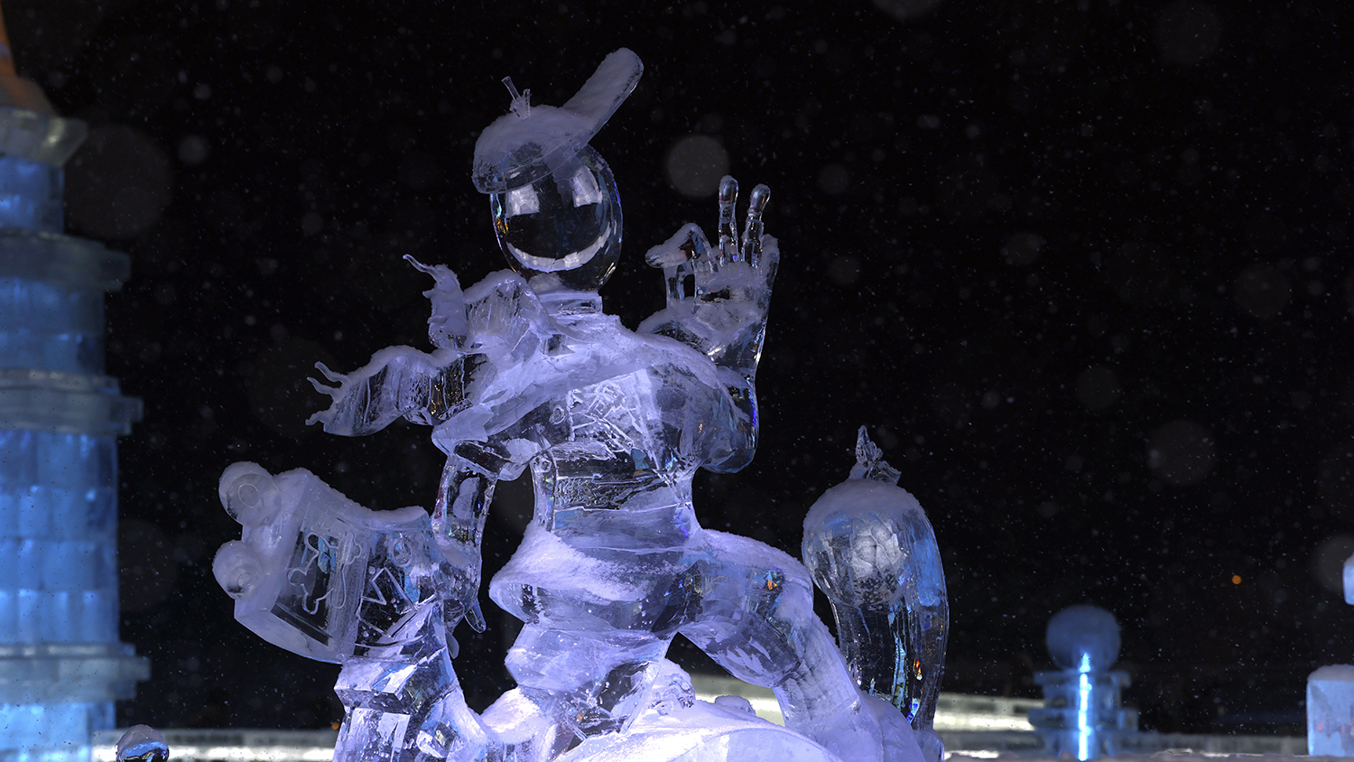 A large ice sculpture of a man in a baseball cap smiling and making a happy gesture.