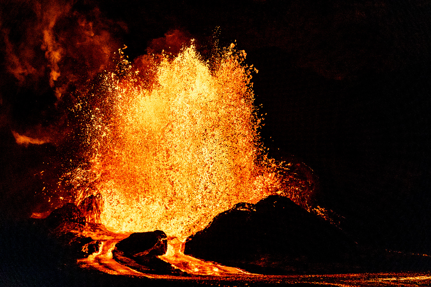 Lava and rock can be seen against a dark background.