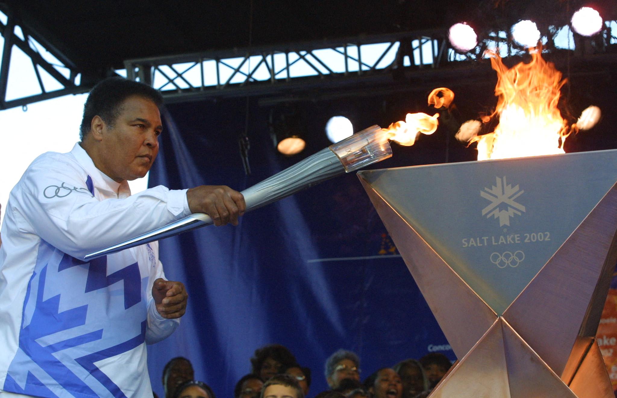 Muhammad Ali lights an Olympic torch that reads Salt Lake City 2002.
