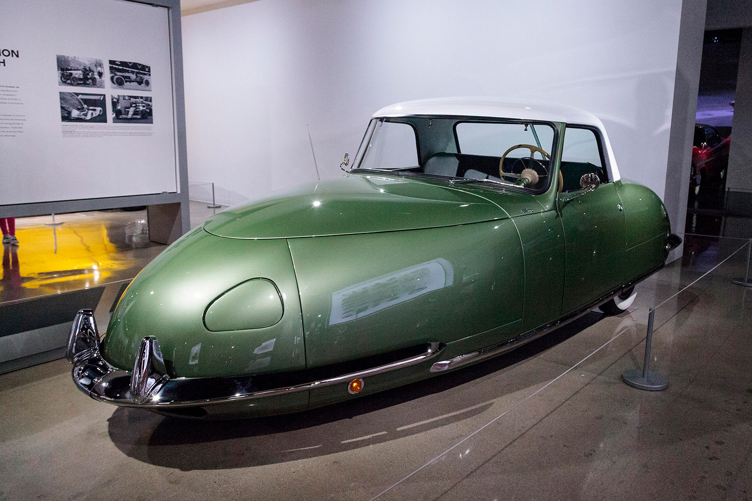 A green Davis Divan sits in an exhibit with a description card next to it.