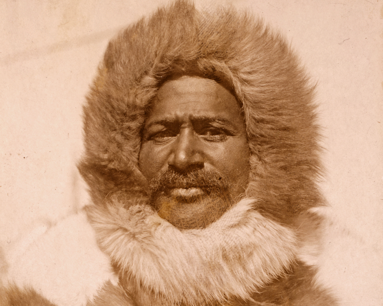 Matthew Henson wears a fur coat with hood.
