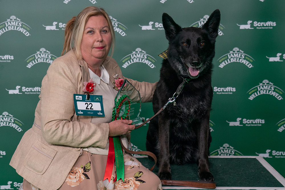 Owner Jennifer Mitchell sits and poses on a bench with her large black dog called Rocky.
