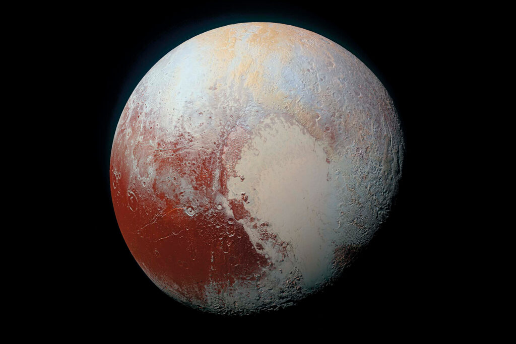 An image of Pluto makes it appear to have red, orange, and white coloration.