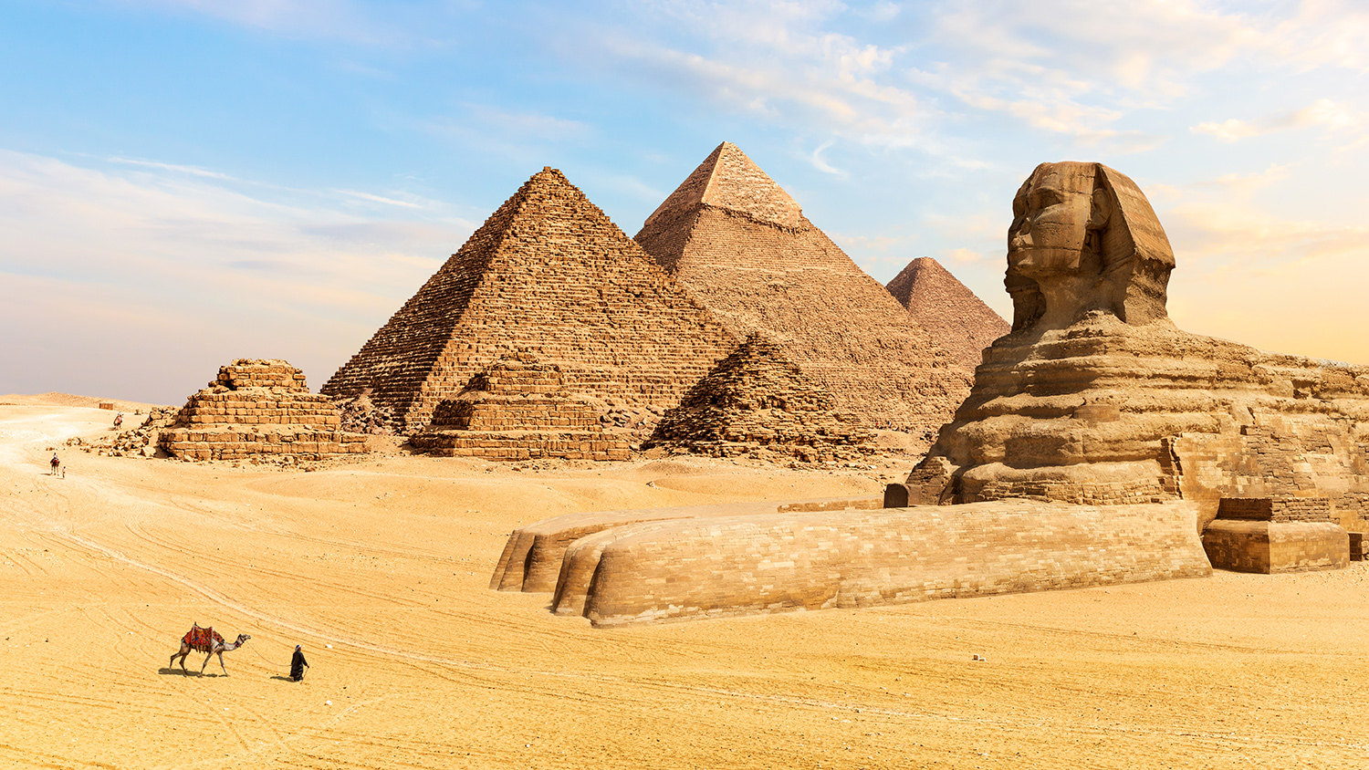 The pyramids of Giza and the Great Sphinx stand in the desert.