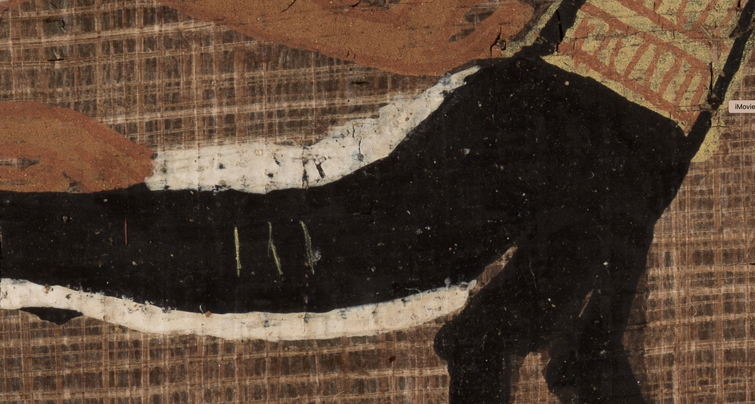 A closeup shows white correction fluid around the painted body of a jaguar.