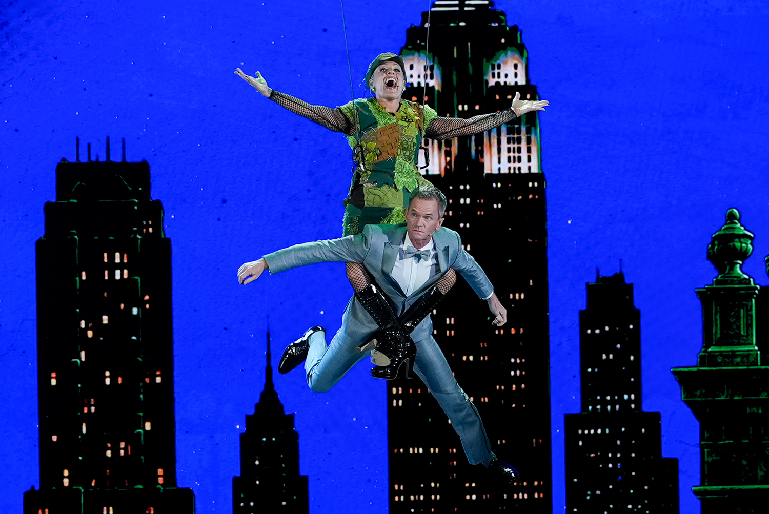 Pink hangs from wires and uses her legs to lift Neil Patrick Harris off the stage.