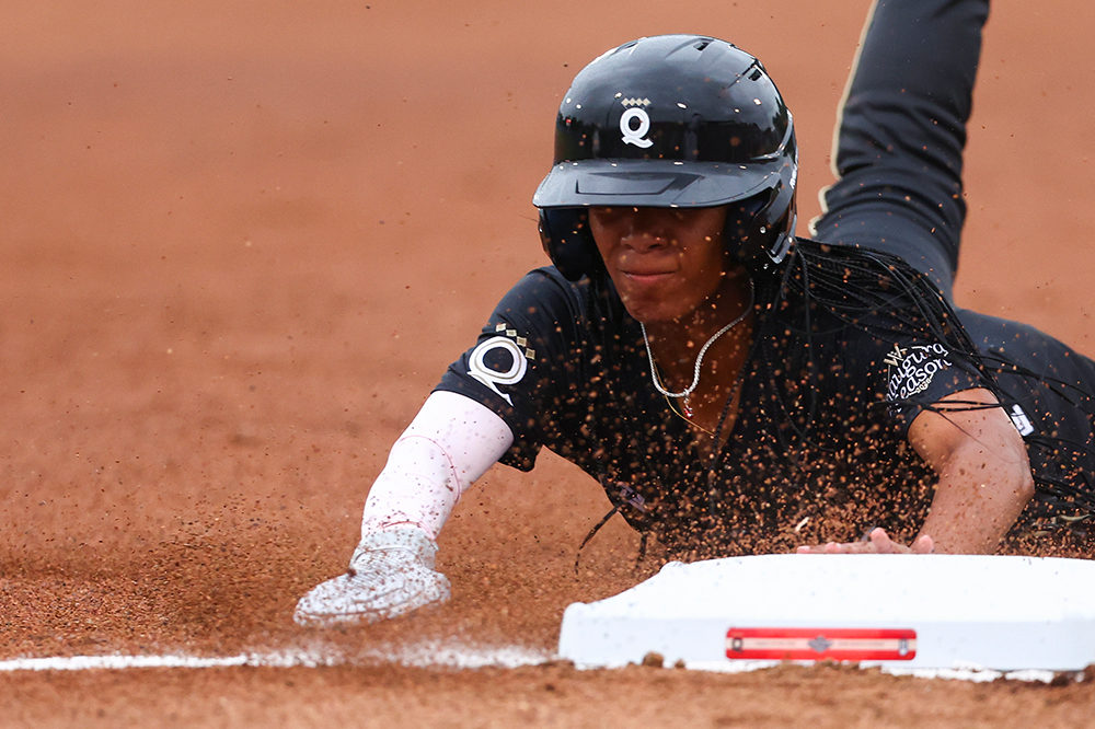 Mo’ne Davis slides into a base on her stomach.
