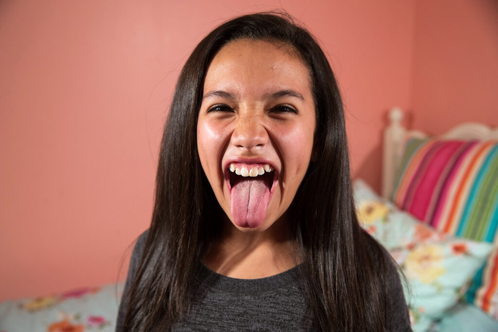 A child playfully sticks out her tongue.