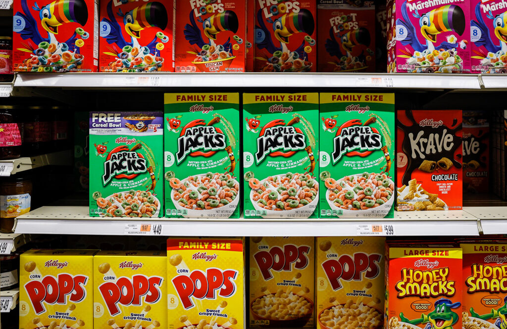Many different Kellogg’s cereals are on shelves in a supermarket.